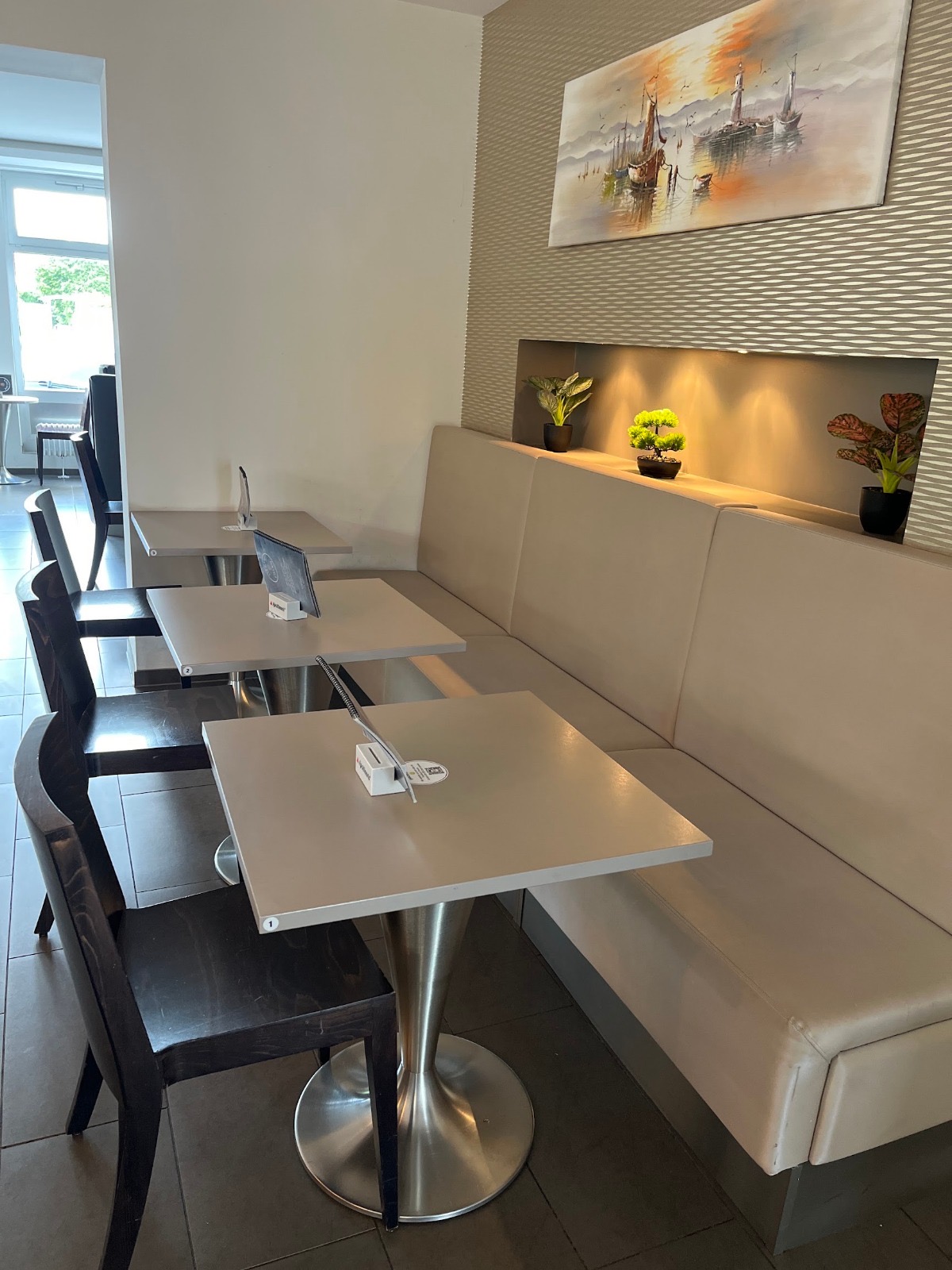 Sitzplätze im Eiscafé Lijano mit Bank und Pflanzen